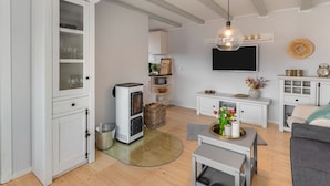 Een moderne woonkamer met een open haard, een flatscreen televisie en een gezellige zithoek.