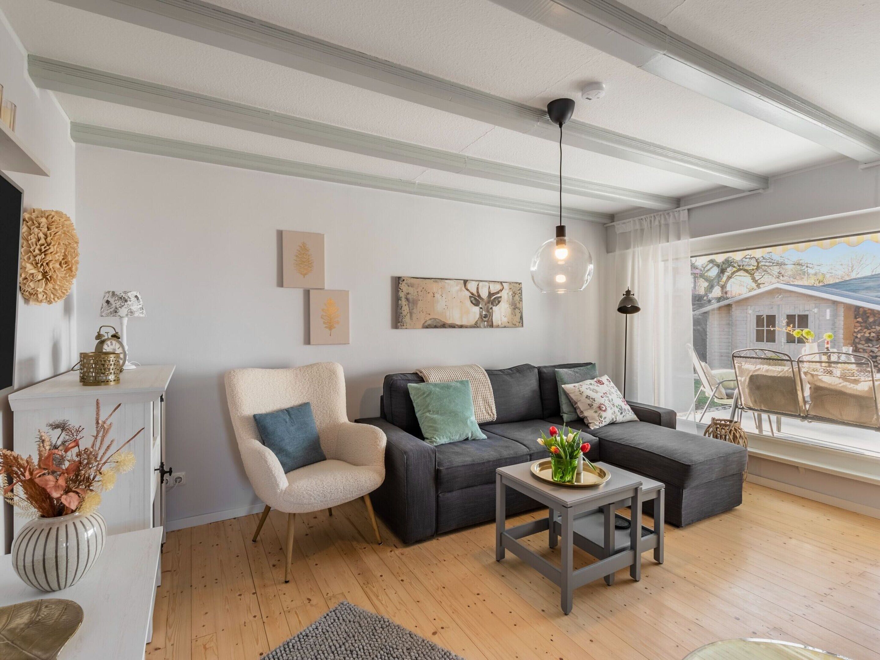 A modern living room with a sectional sofa, a small side table, and a decorative lamp.