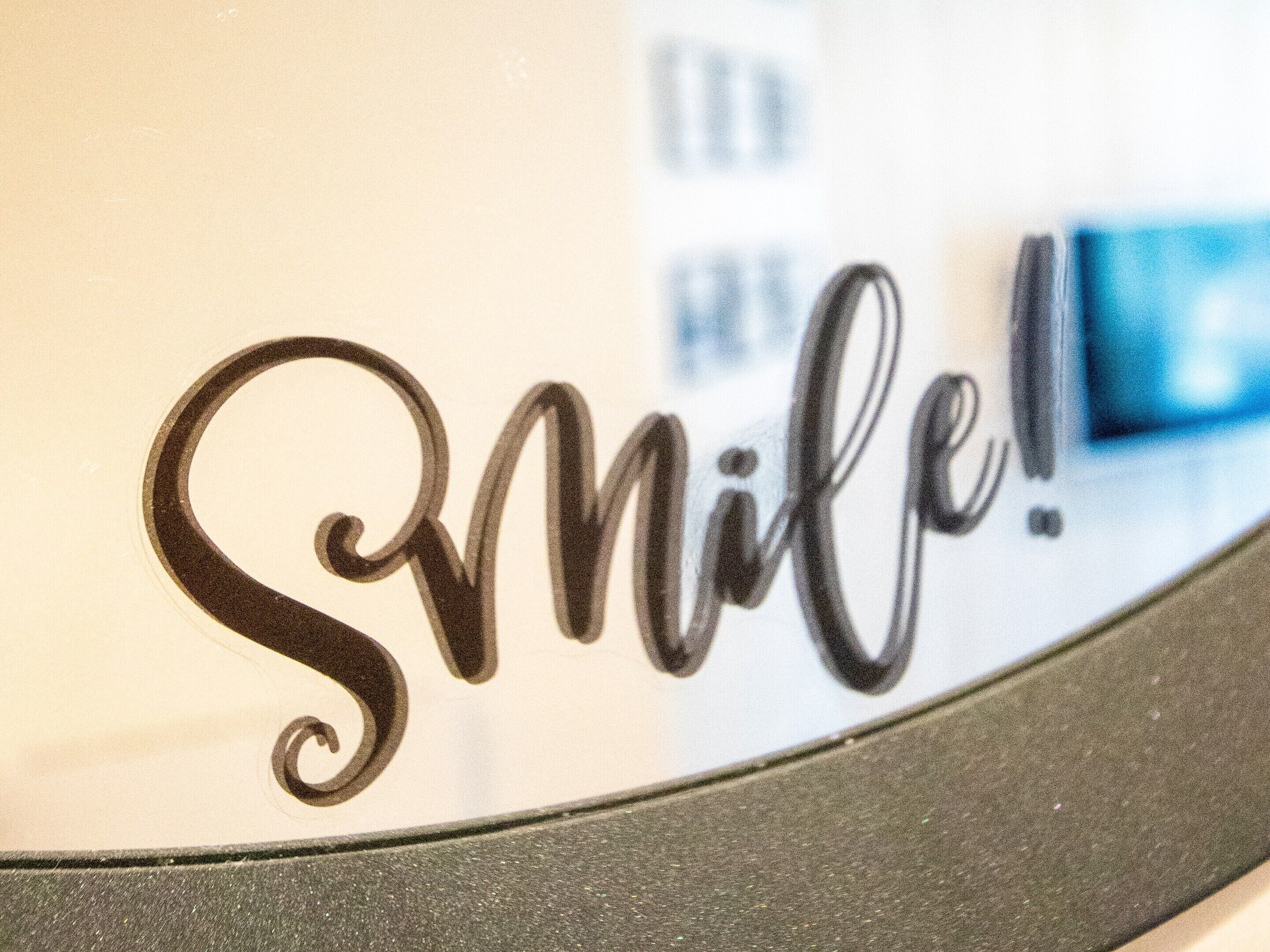 A wall with the word "Smile!" in cursive writing.