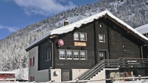 Un bâtiment traditionnel en bois, sur lequel on peut lire l’inscription « Talblick », et un escalier menant à l’entrée.