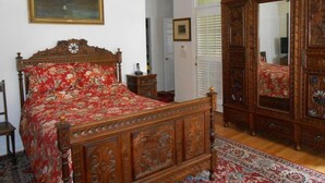 A bedroom with a wooden bed, a large mirror, and a painting on the wall. - Spacious Holiday Home in Sluknov With Private Garden (Sluknov)