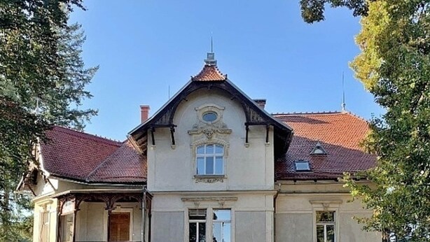 A large, historic building with a symmetrical facade, a central entrance, and a red-tiled roof. - Spacious Holiday Home in Sluknov With Private Garden (Sluknov)