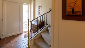 A staircase with a handrail leading to a landing, a door on the left, and a framed artwork on the wall. - Nice Holiday Home in Ostend by the sea With a Terrace (Ostend)