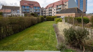 A residential complex with multiple apartment buildings, a well-maintained lawn, and a variety of vegetation. - Nice Holiday Home in Ostend by the sea With a Terrace (Ostend)