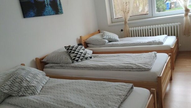 A room with three wooden beds, each with a patterned pillow and a blanket. - Cozy Apartment in Eastern Bohemia Near Town Center (Vysoke Myto)
