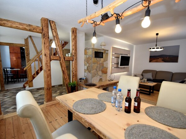 Cozy living space with a dining table, sofa, and mounted TV.