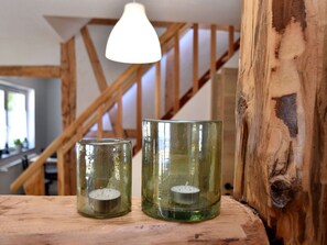 Candles illuminate the rustic space with a wooden staircase in the background.