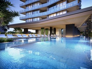 A modern hotel with a rooftop infinity pool, lounge chairs, and a multi-story building with balconies.
