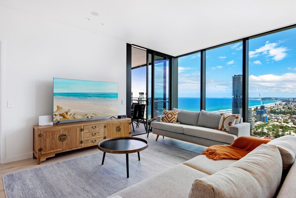 A modern living room with a large TV, a sofa, and a coffee table.