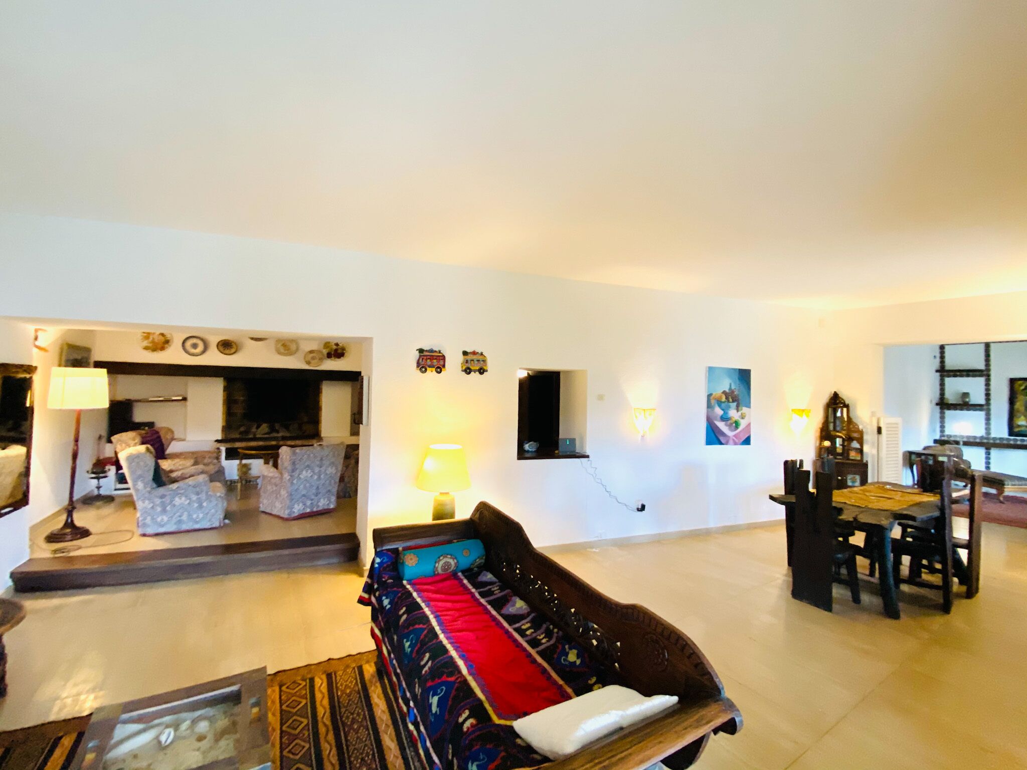 Un amplio salón con sofá, una mesa de comedor y una chimenea.