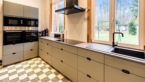 Eine moderne Küche mit integrierten Geräten, einem großen Fenster und einem Schachbrettfußboden.