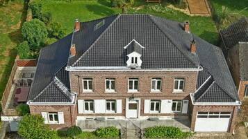 A large, two-story house with a symmetrical facade, a central chimney, and a garage.