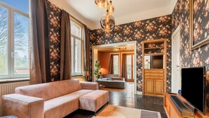 Ein modernes Wohnzimmer mit einer Couch, einem Fernseher und einer Küchenzeile mit Holzausstattung.
