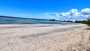 Une plage avec un rivage sablonneux et un ciel bleu dégagé.