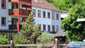 A multi-story building with balconies, surrounded by greenery. - Apartment in Deudesfeld With Private Terrace (Schutz)