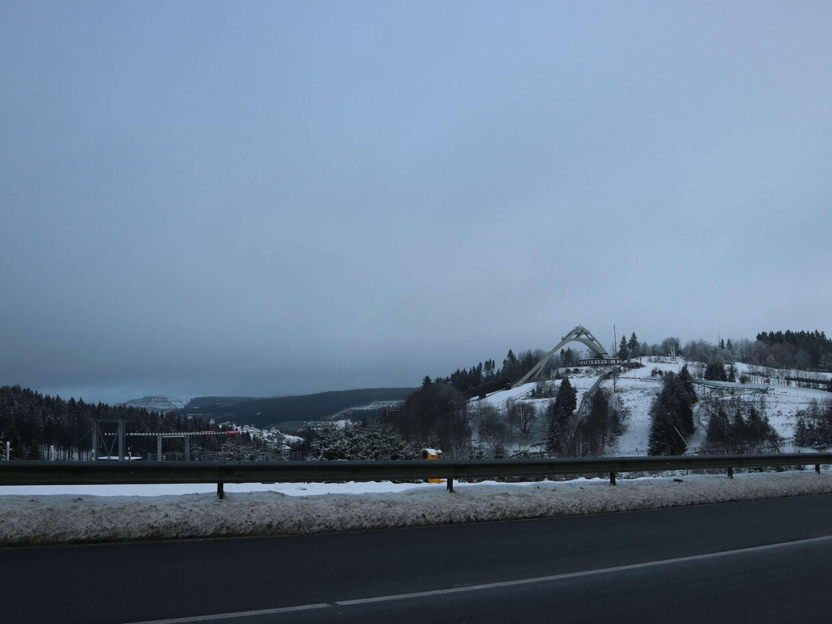 Paisaje nevado con un puente y una carretera.