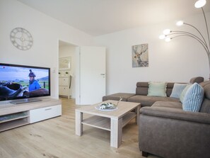 Relax in this stylish living room with a flat-screen TV, comfortable sofa, and a coffee table.