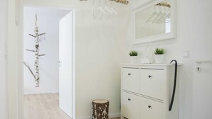 A hallway with a white wardrobe, a mirror, and a hanging light fixture. - Kleine Wohnung Nahe von Winterbergs Skikarussell (Winterberg)