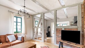 Ein gemütliches Wohnzimmer mit einer Holzsofa, einem Couchtisch, einem Fernseher und einem Kamin.