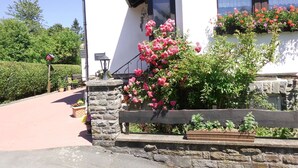 A stone wall with a wooden bench, a stone lantern, and a sign that reads "Hauptstraße". - Apartment in Langewiese Near Winterberg (Winterberg)