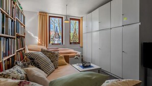 A cozy room with a bed, a bookshelf, a desk, and a wardrobe. - Flat in Meldorf Next to the Town Centre (Meldorf)
