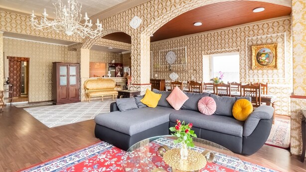 A spacious living room with a large sofa, a coffee table, and a chandelier. - Apartment in Kinheim With Lots of Space (Kinheim)