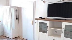 A room with a white wardrobe, a closed door, and a TV on a wooden shelf. - Ferienwohnung im Idyllischen Ziesar (Ziesar)