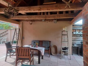 A rustic outdoor patio with wooden furniture, a table, and a bench. - Ferienwohnung im Idyllischen Ziesar (Ziesar)