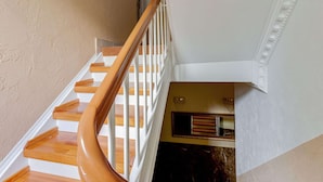 A staircase with wooden steps and white railings, leading to a landing with a dark marble wall and a small window. - Apartment in Oberhausen Near Dusseldorf (Oberhausen)