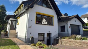 A two-story house with a sloped roof, a large window with yellow trim, and a satellite dish on the roof. - Wohnung in Frankenberg fur Radfahrer (Frankenberg)