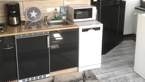 A compact kitchen with a microwave, coffee maker, and a small refrigerator. - Snug Apartment in Grevesmuhlen With Terrace (Grevesmuehlen)