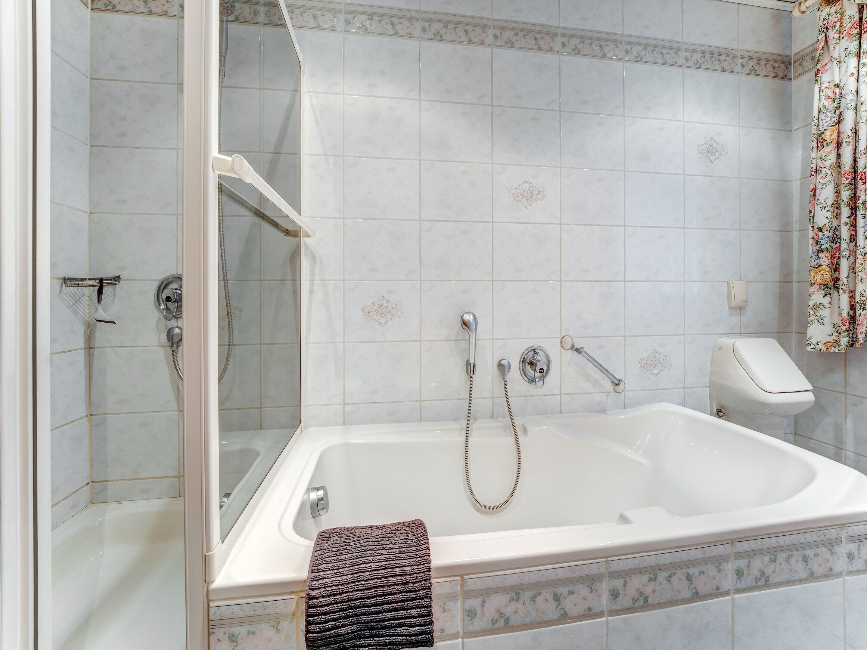 Un baño con bañera, ducha y retrete.