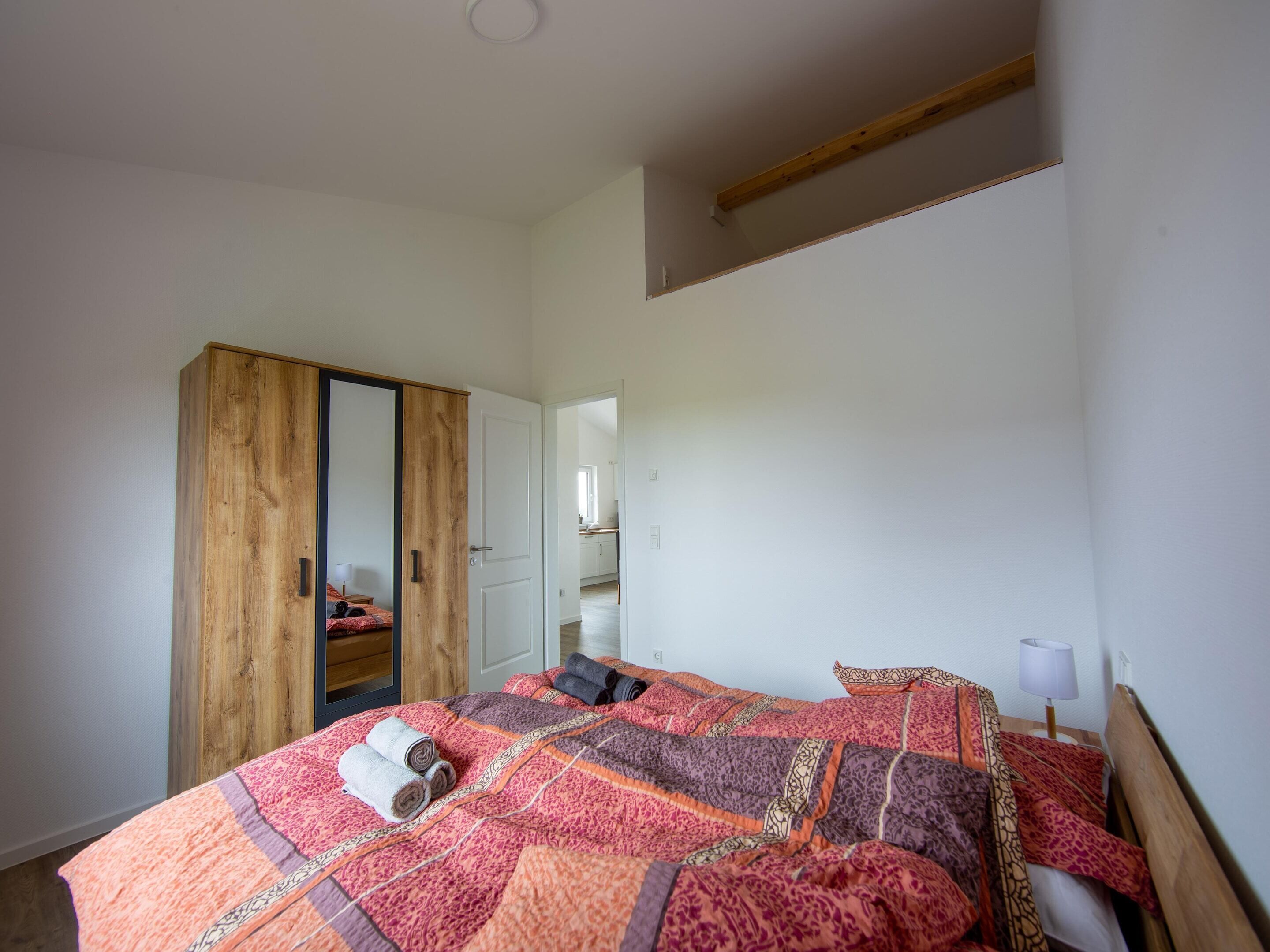 Ein Schlafzimmer mit einem großen Bett, einem Holzschrank und einem kleinen Schreibtisch.