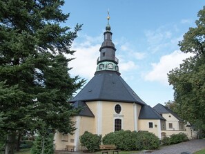 Una chiesa con un campanile imponente e una torre dell'orologio.