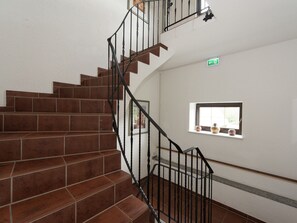 Stairs lead to an upper floor with a window above, offering a view of the surrounding area.