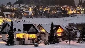 A snow-covered residential area with houses featuring balconies and large windows. - Apartment With Balcony in Neuastenberg (Winterberg)