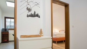 A bedroom with a bed, a dresser, a microwave, and a window. - Apartment With Balcony in Neuastenberg (Winterberg)