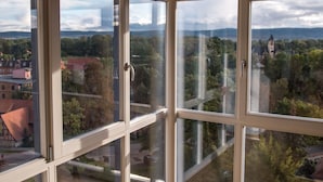 A room with large windows offering a view of a town and mountains. - Elegant Escape in Quedlinburg (Quedlinburg)