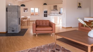 A spacious living area with a wooden ceiling, a brown leather sofa, a wooden coffee table, and a patterned rug. - Elegant Escape in Quedlinburg (Quedlinburg)