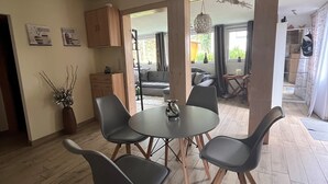 Une cuisine moderne avec un coin repas, un plancher en bois et une vue sur le salon.
