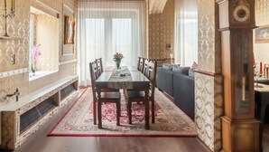 A dining room with a wooden table, chairs, and a sofa. There is a fireplace on the left and a clock on the right. - Exceptional Holiday Flat in Kinheim (Kinheim)