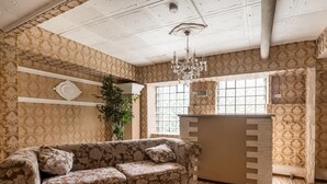 A room with a floral-patterned sofa, a wooden cabinet, and a large window with decorative glass. - Exceptional Holiday Flat in Kinheim (Kinheim)