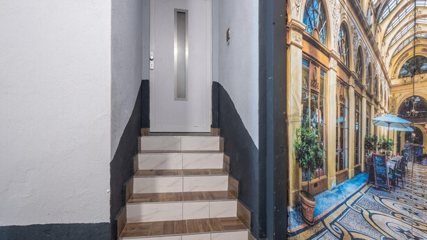 A staircase leading to a room with a view of a grand, ornate building with a glass ceiling. - Exceptional Holiday Flat in Kinheim (Kinheim)