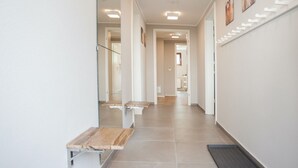 A modern hallway with recessed lighting, a bench, and a door leading to another room. - Apartment With Terrace Near Niedersfeld Forest (Winterberg)
