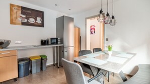 Eine moderne Küche mit Mikrowelle, Kühlschrank und Essbereich mit Tisch und Stühlen.