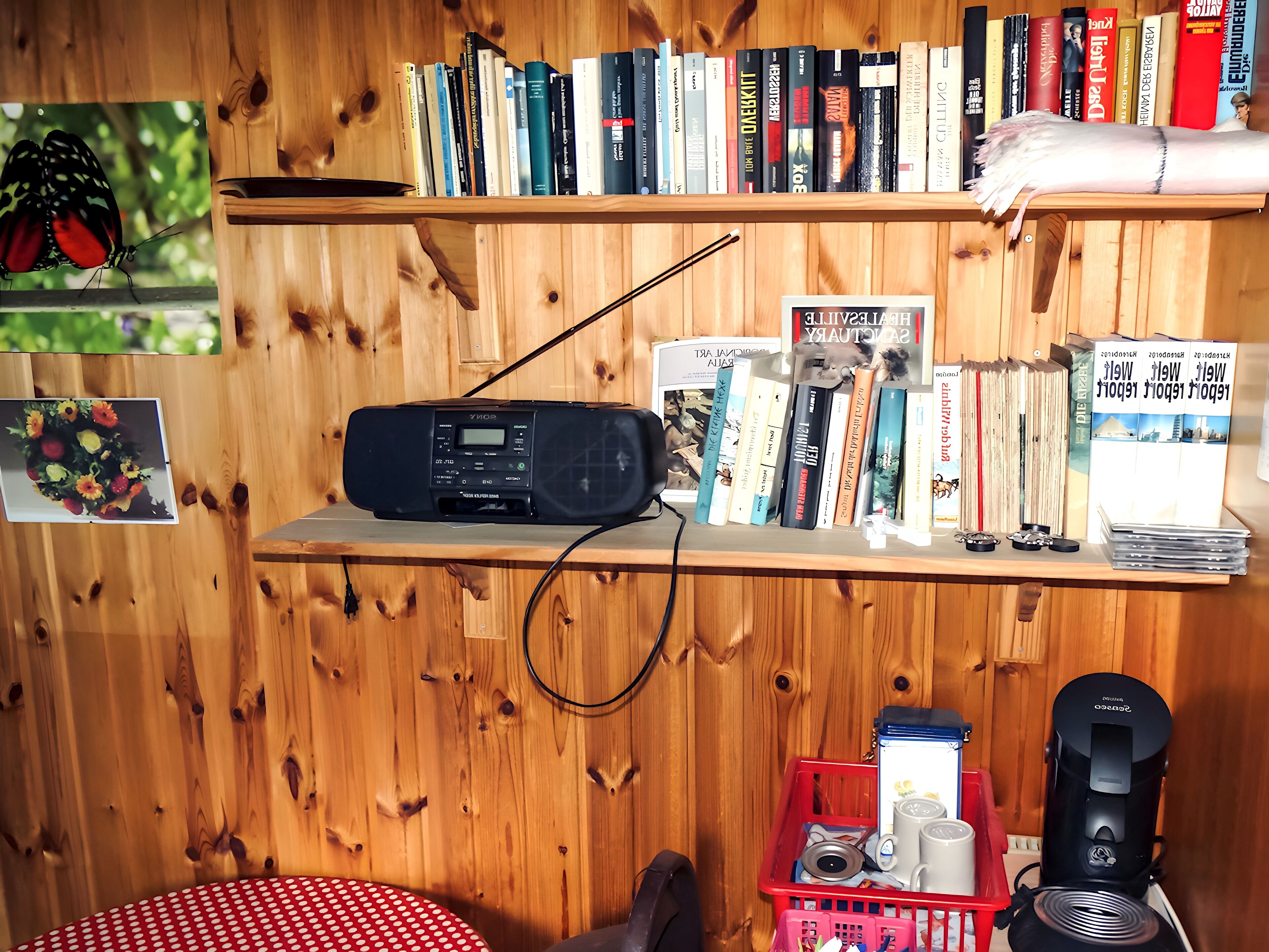 A wooden bookshelf with books, a Sony radio, and a coffee maker.