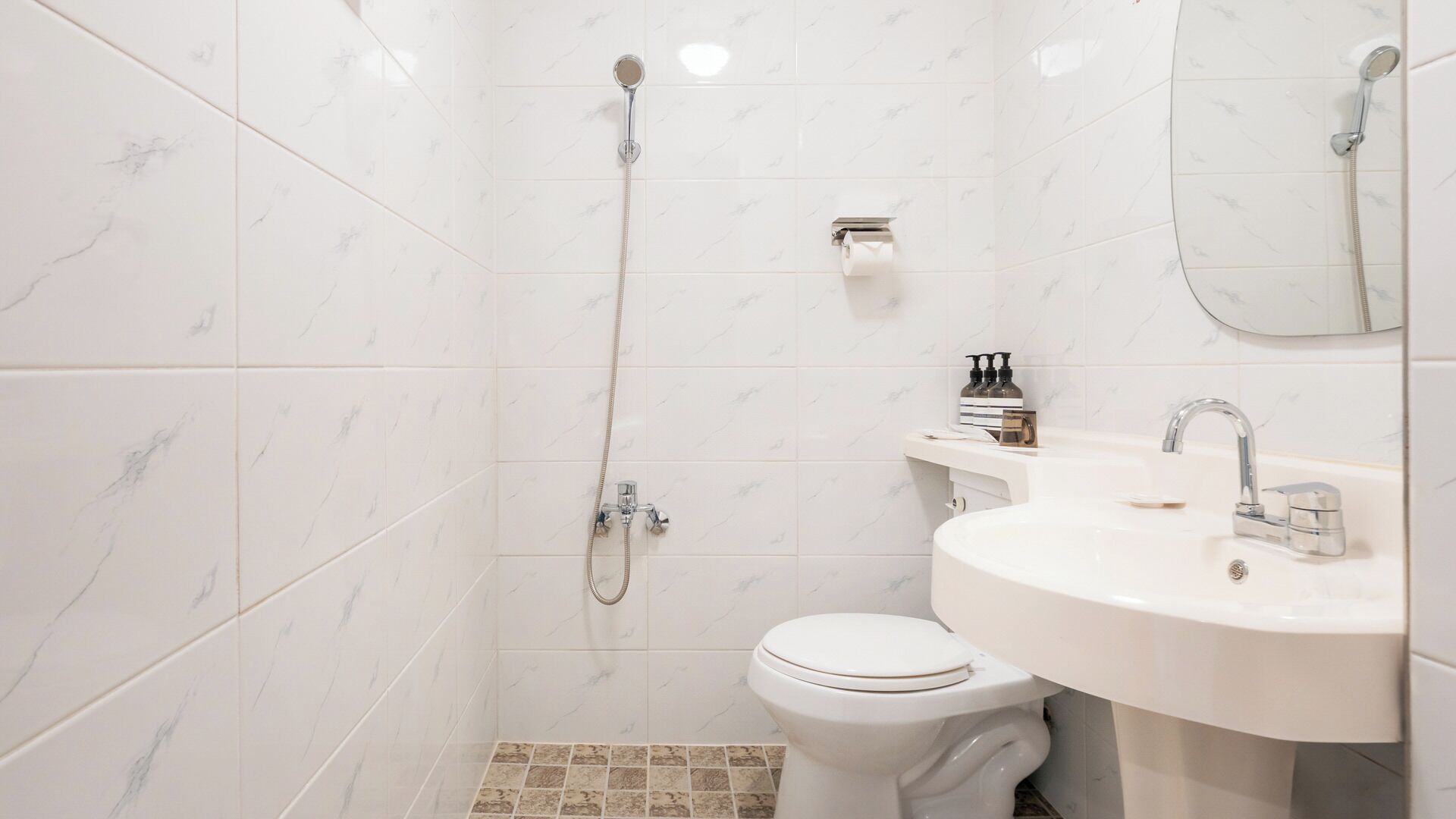 Un baño con inodoro, lavamanos y ducha.