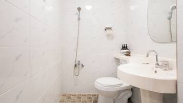 Un baño con inodoro, lavamanos y ducha.