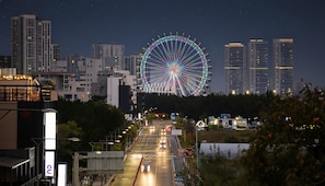A cityscape at night with a prominent Ferris wheel and modern high-rise buildings. - Sokcho Pensionbyeol (Sokcho)
