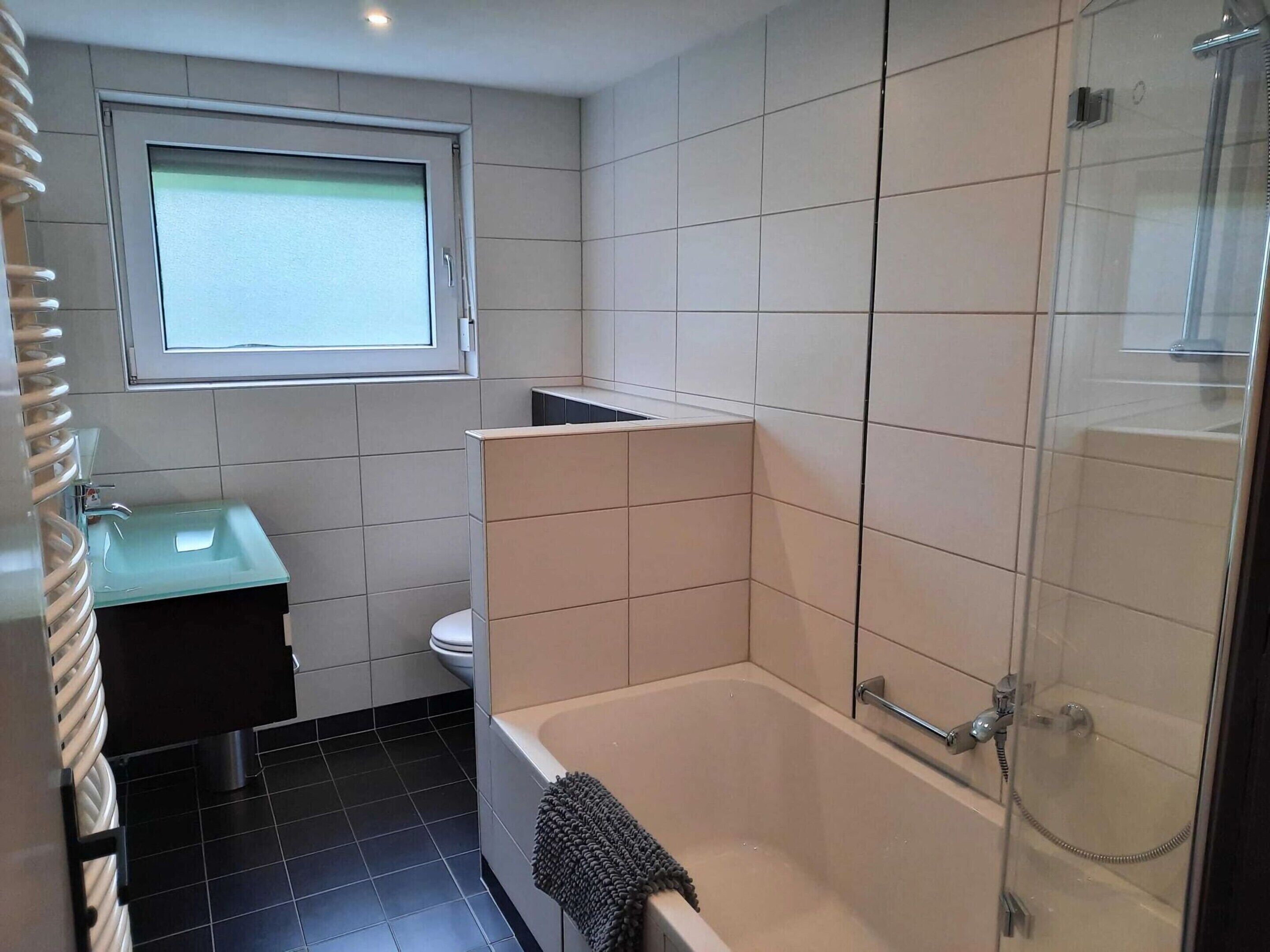 A modern bathroom with a bathtub, a shower, and a sink.